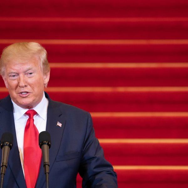 President Trump talking against a red backdrop.