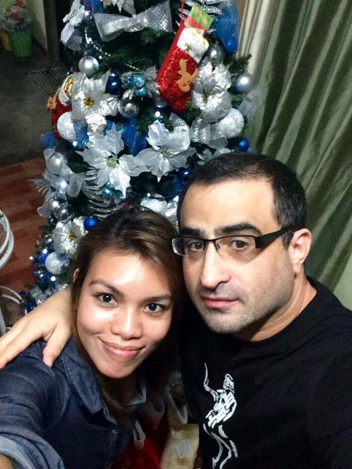 Adam and Charmay in front of their Christmas tree, December 2016