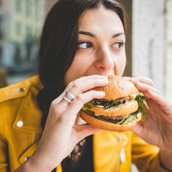 An immigrant woman eating a burger
