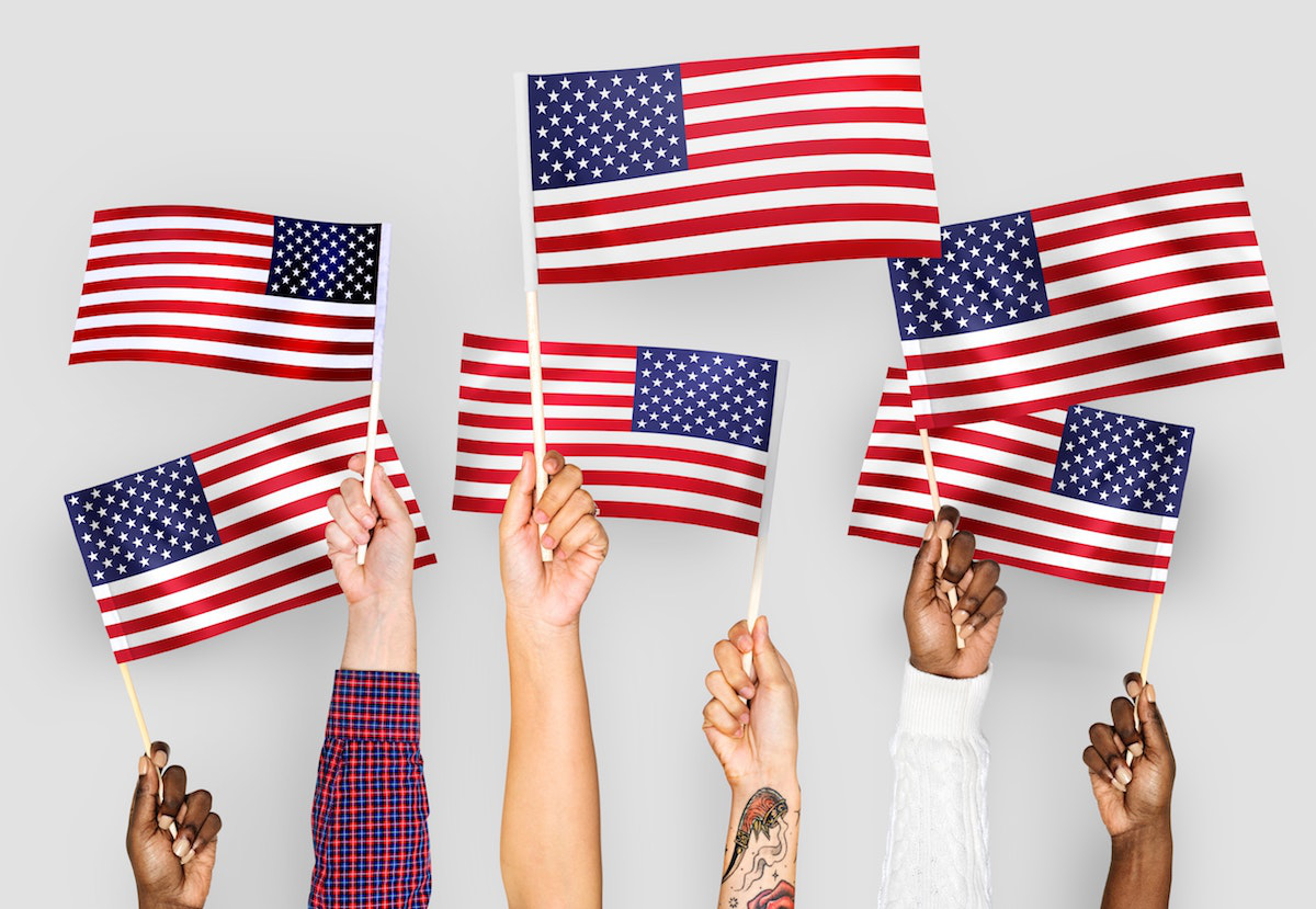 Hands of American Citizens Raising US Flags